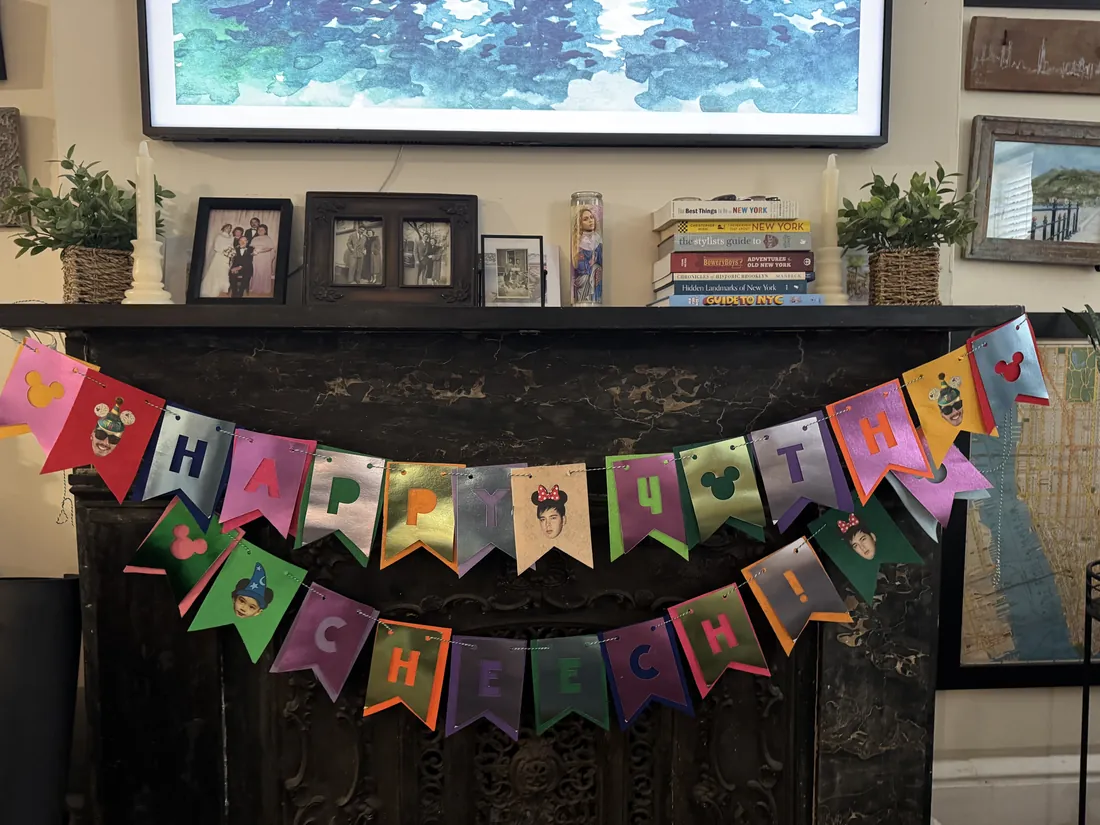 A handmade felt birthday banner strung across a mantelpiece, spelling out a happy birthday message in cut letters.